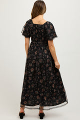 woman wearing a black floral maternity maxi dress with short sleeves and a smocked bodice, showing her baby bump