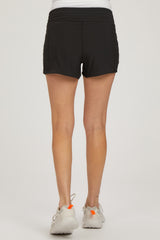 woman wearing black maternity shorts with a relaxed fit and side ruching, showing the back view