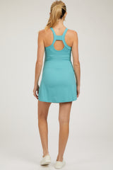 woman wearing a turquoise maternity active skort with a racerback design, showing a smooth back view