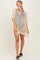 woman wearing a beige crochet cover-up dress with short sleeves and a v-neckline