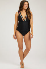woman wearing a black maternity swimsuit with colorful embroidered detailing and a plunging neckline