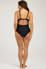 woman wearing a black maternity swimsuit, showing a scoop back design and adjustable straps