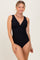 woman wearing a black scalloped edge one-piece swimsuit with a deep v-neck and ribbed texture