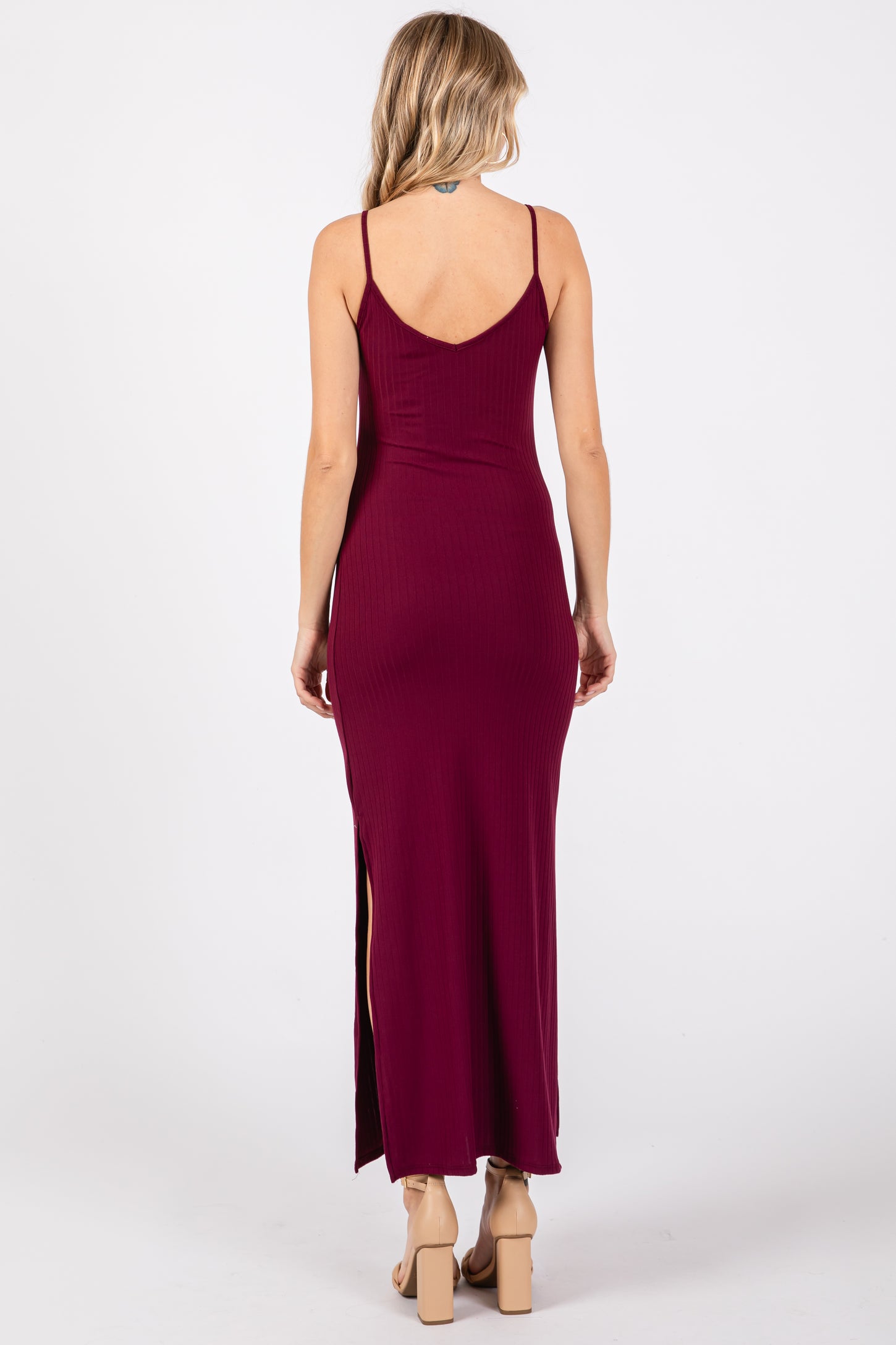 woman wearing a burgundy ribbed maxi dress with a high side slit and thin straps, viewed from the back