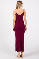 woman wearing a burgundy ribbed maxi dress with a high side slit and thin straps, viewed from the back
