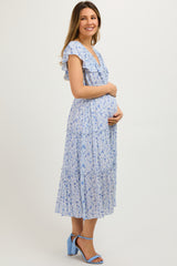 woman wearing a light blue floral maternity maxi dress and holding her baby bump
