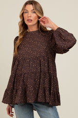 woman wearing a brown tiered maternity top with a polka dot pattern and long puff sleeves
