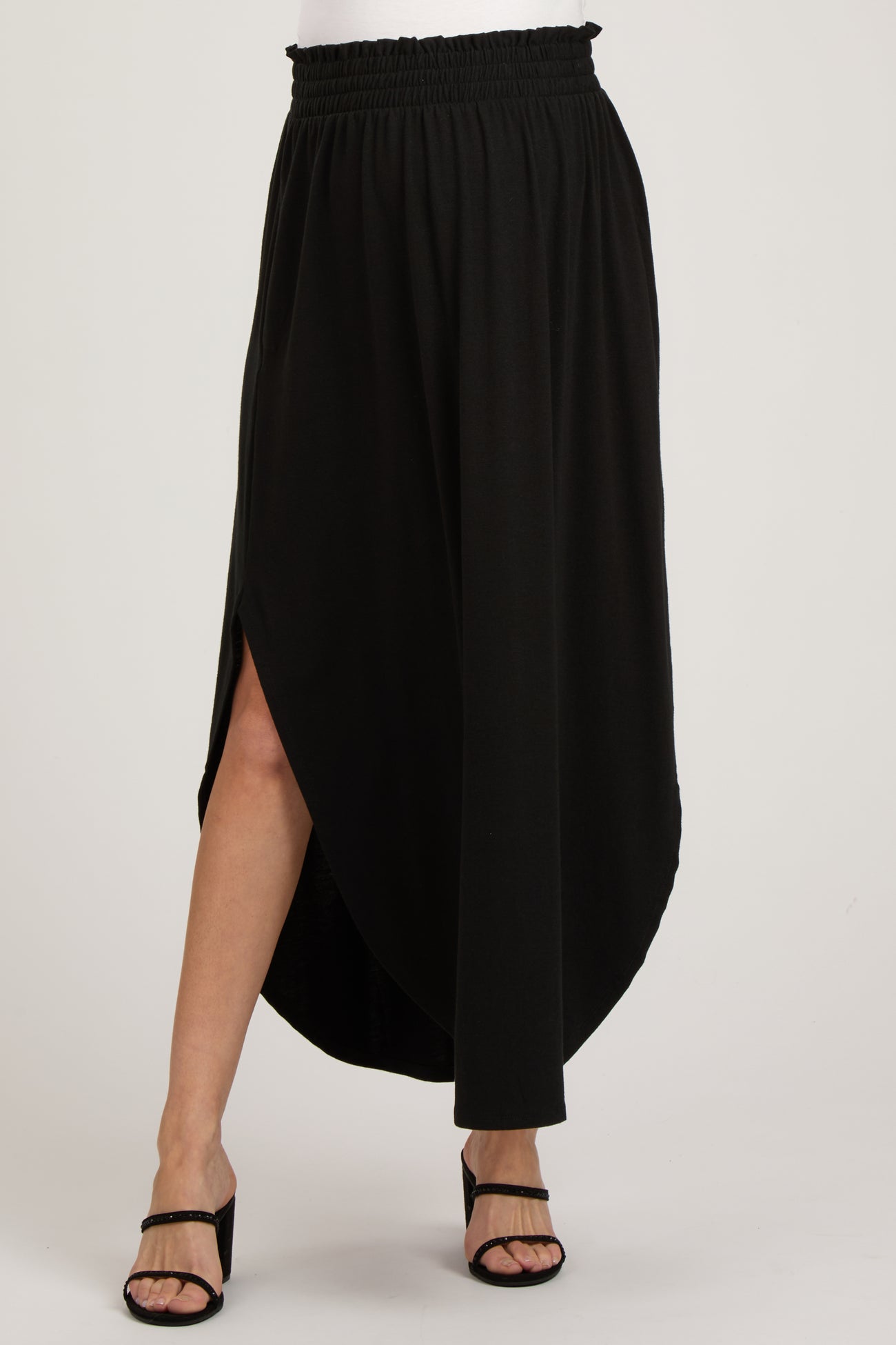woman wearing a black maternity maxi skirt with a high-low hem and an elastic waistband