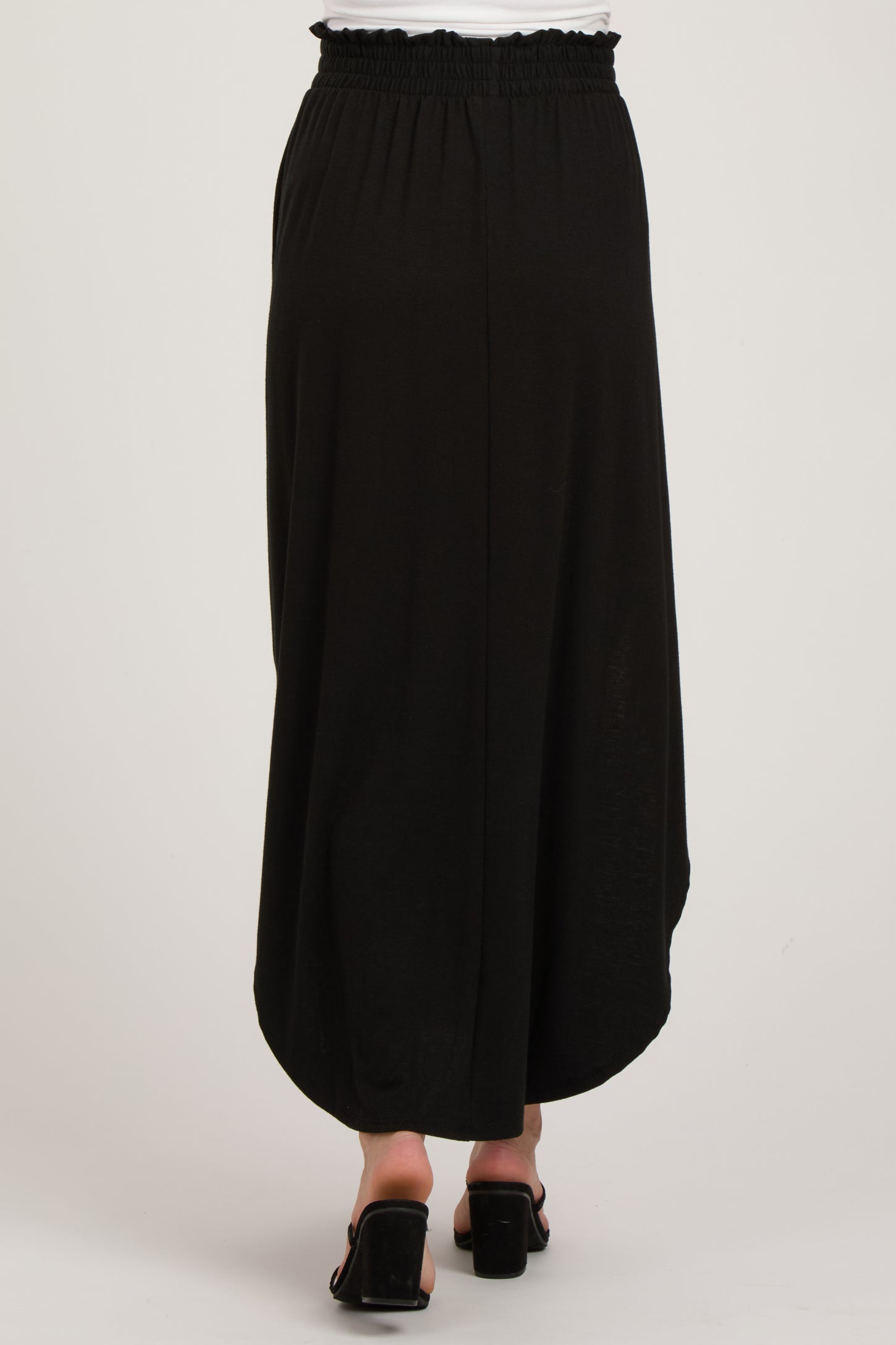 maternity wear black maxi skirt with smocked waistband, shown from the back, model wearing sandals