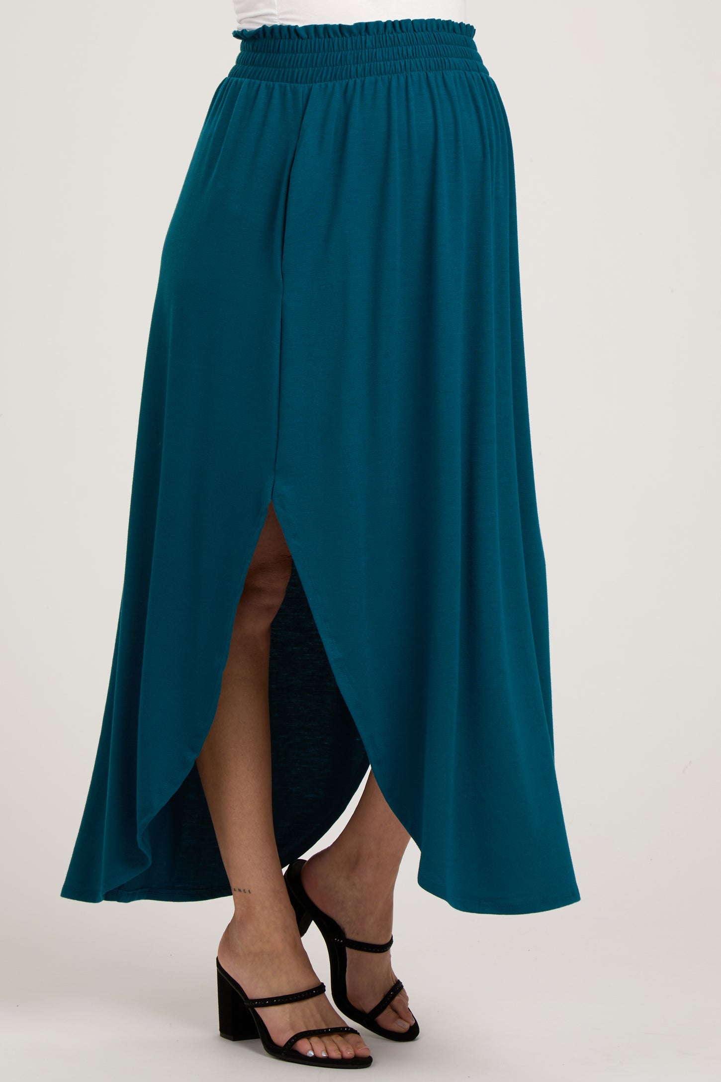 woman wearing a teal maternity maxi skirt with a high slit and elastic waistband