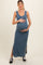 woman wearing a blue ribbed maternity maxi dress with side slits and holding her baby bump