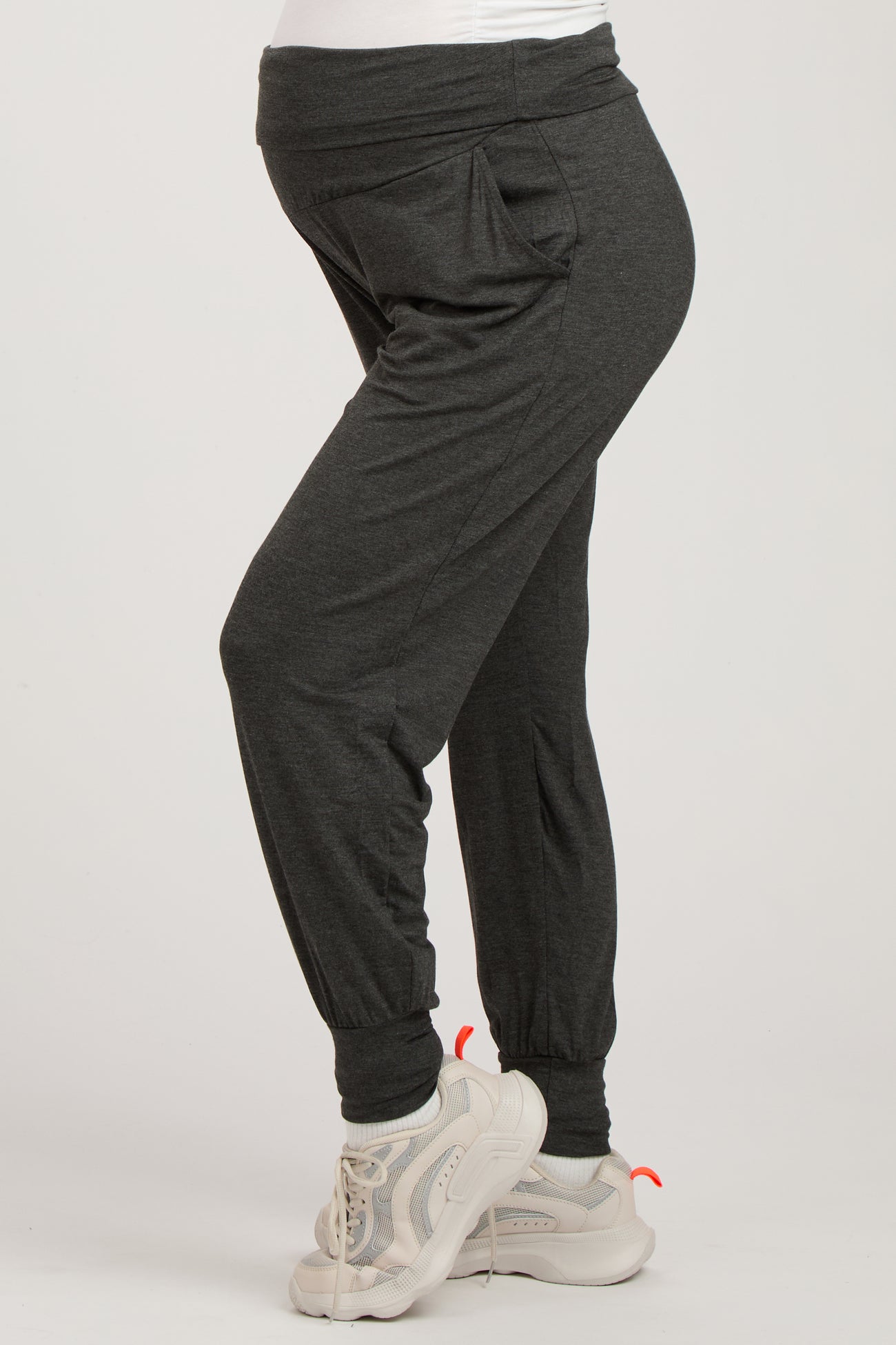 woman wearing dark gray maternity joggers with a comfortable waistband and side pockets