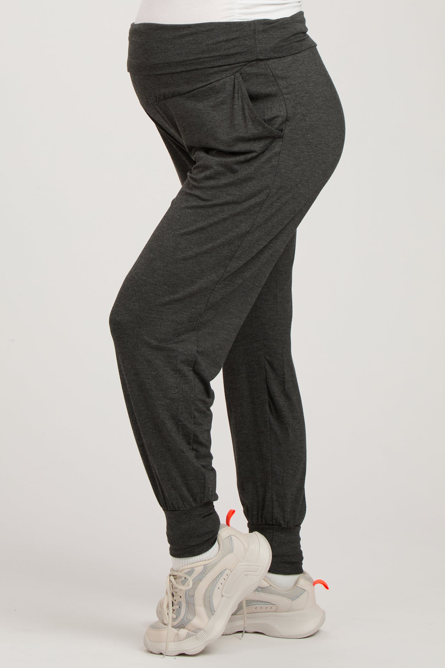 woman wearing dark gray maternity joggers with a comfortable waistband and side pockets