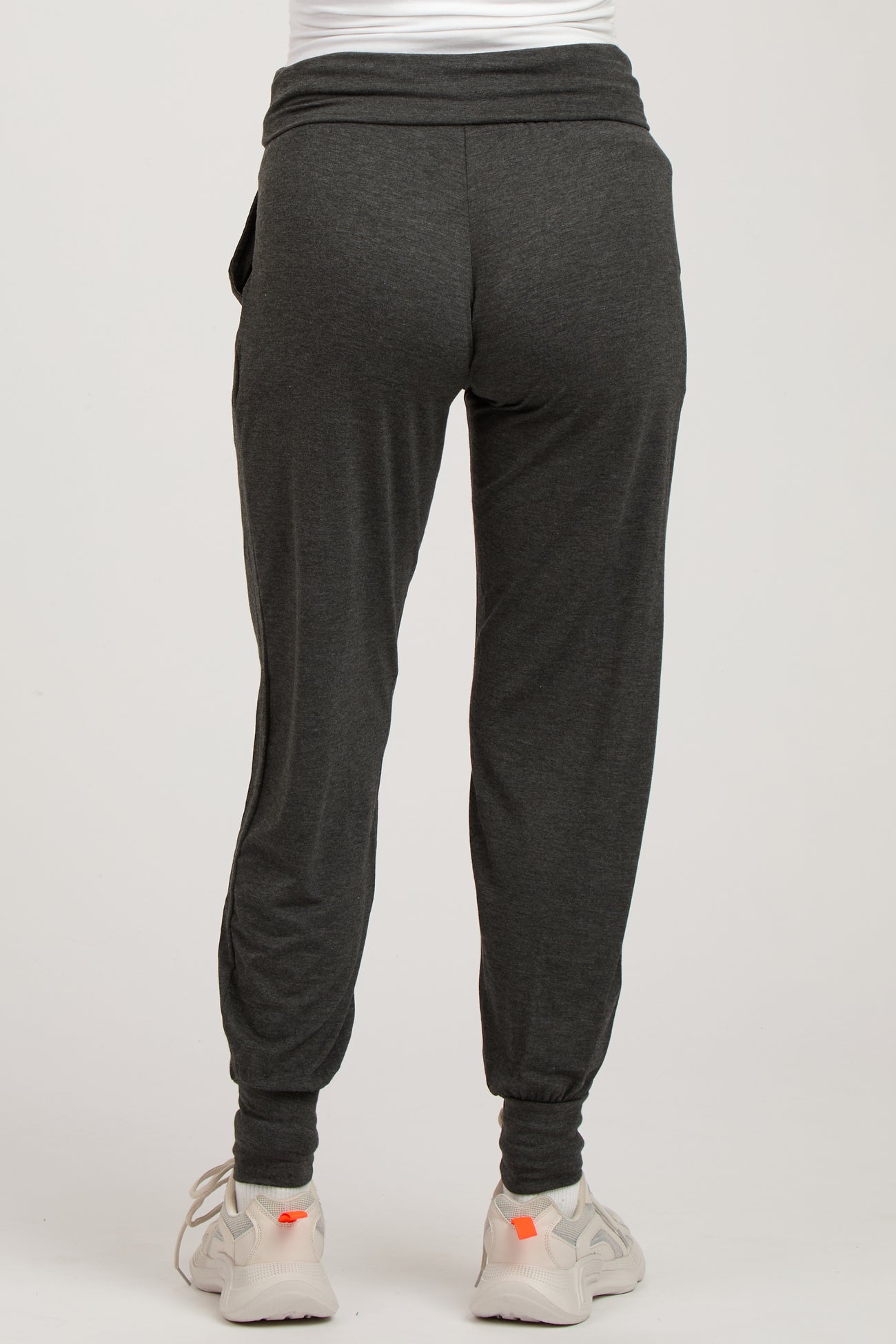 woman wearing dark gray maternity joggers with a fitted ankle and comfortable waistband, styled for casual wear