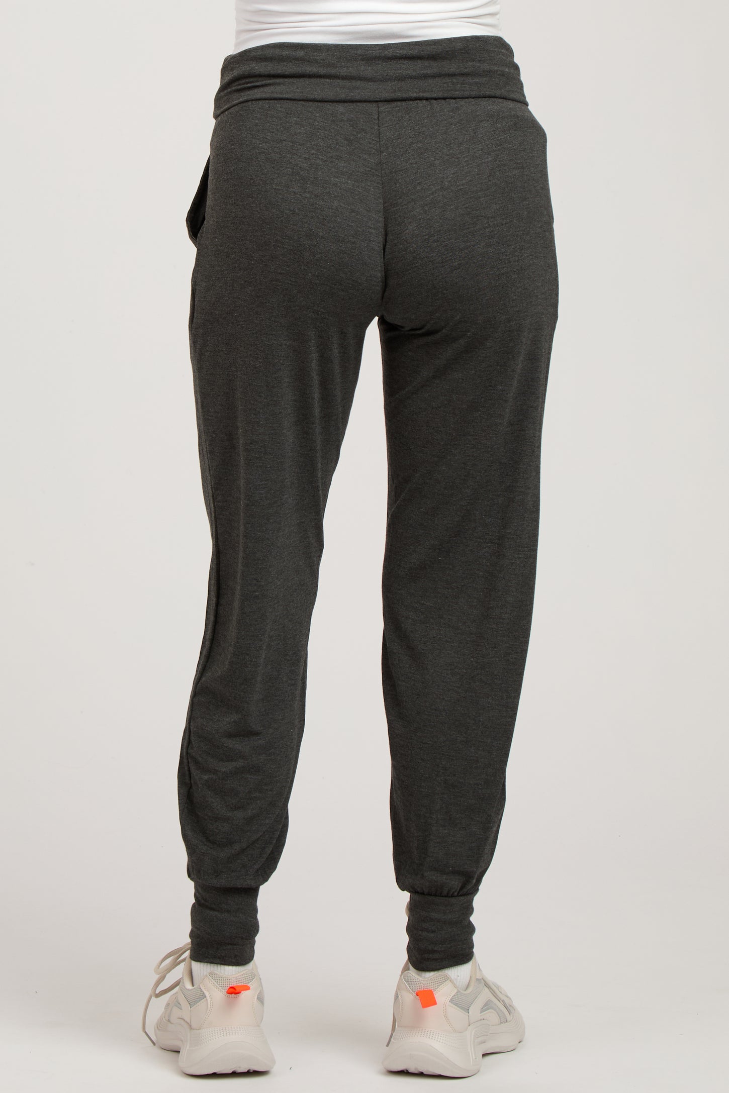 woman wearing dark gray maternity joggers with a fitted ankle and comfortable waistband, styled for casual wear