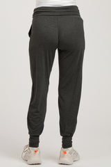 woman wearing dark gray maternity joggers with a fitted ankle and comfortable waistband, styled for casual wear