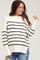 woman wearing a cream and black striped maternity sweater with side slits and relaxed fit