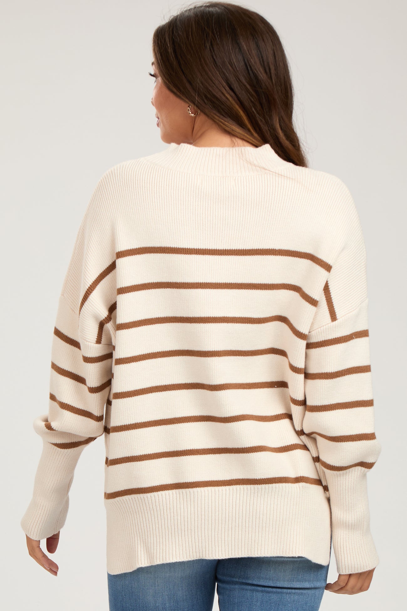 woman wearing a beige and brown striped maternity sweater, showing the back view with a relaxed fit