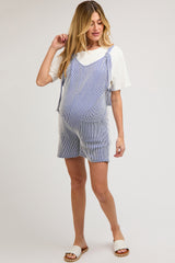 woman wearing a blue and white striped maternity overall dress with adjustable straps and a visible baby bump