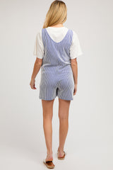 woman wearing a striped blue and white maternity romper and a white short sleeve top, view from the back