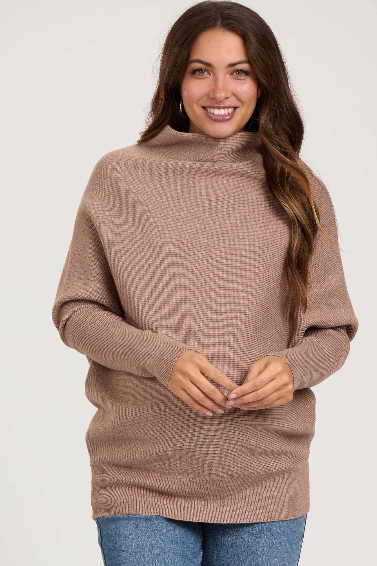 woman wearing a taupe oversized maternity sweater with a cowl neck and long sleeves