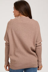 woman wearing a soft beige maternity sweater with a relaxed fit and ribbed texture, showing the back view