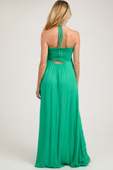 woman wearing a green maternity maxi dress with a smocked back and halter tie straps