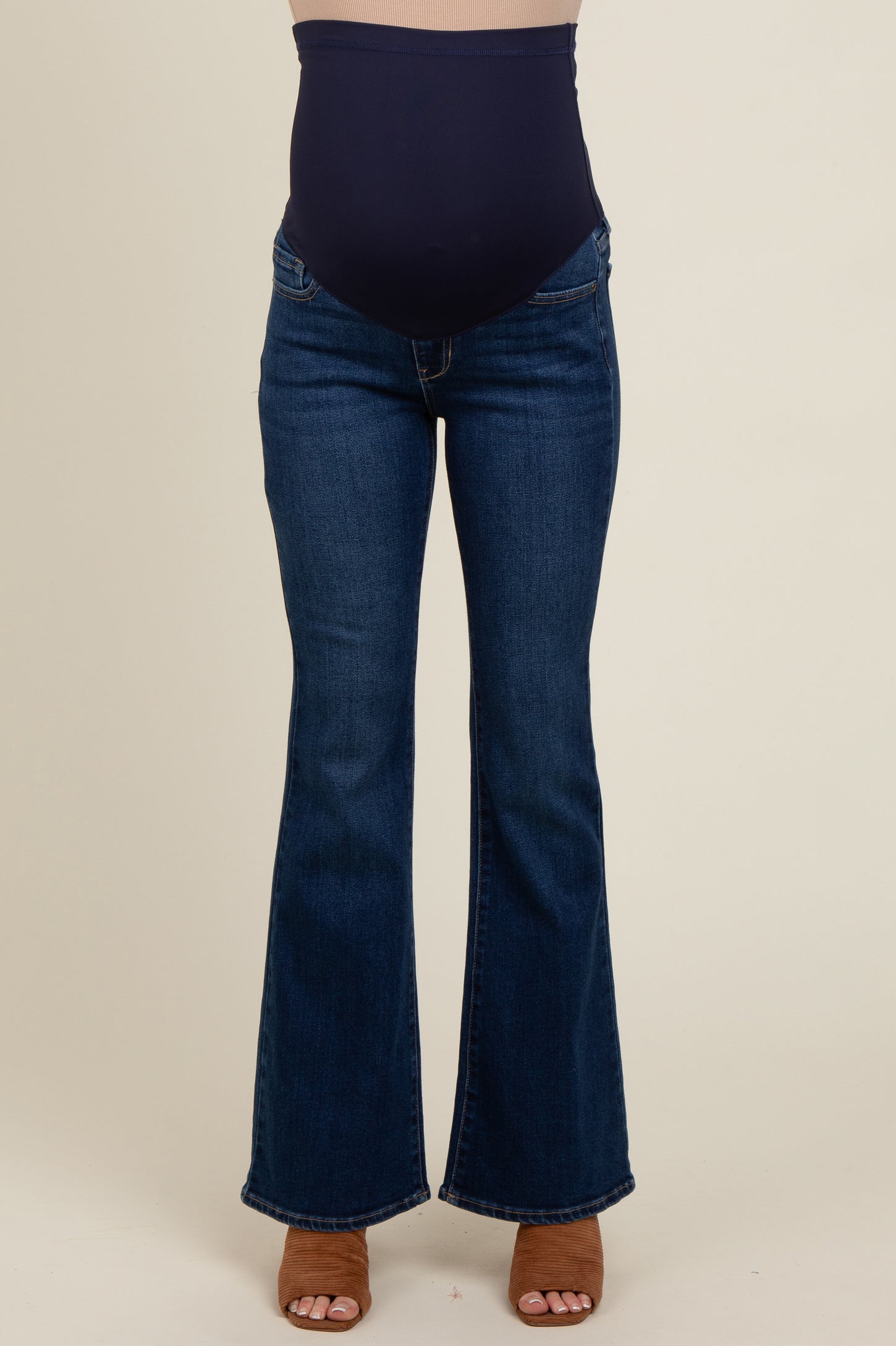 woman wearing dark blue maternity flared jeans with a supportive belly panel