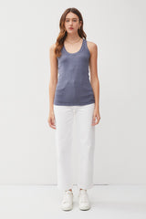 woman wearing a dark blue fitted tank top and white wide-leg pants with sneakers