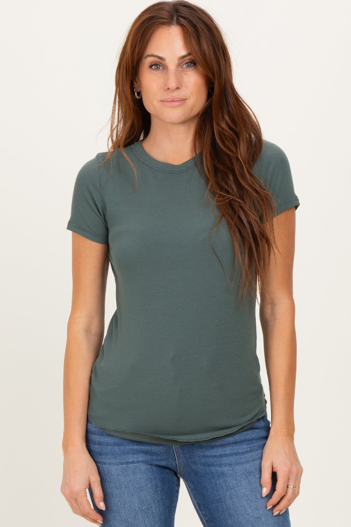 woman wearing a dark green short sleeve ribbed t-shirt and blue jeans