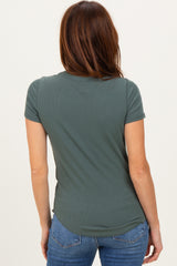 woman wearing a dark green short sleeve fitted top with a curved hem and styling with jeans