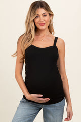 woman wearing a black maternity tank top and holding her baby bump