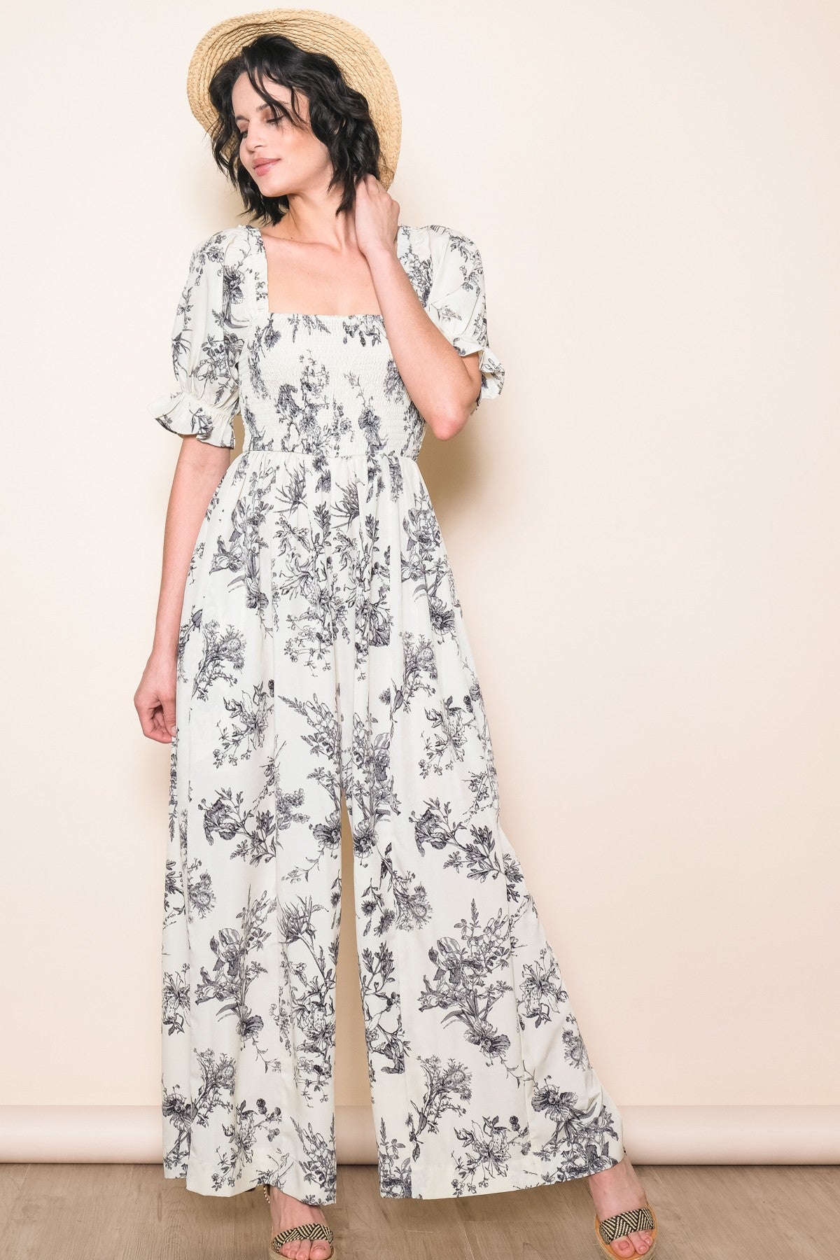 woman wearing a white floral maxi dress with puff sleeves and a square neckline