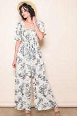 woman wearing a white floral maxi dress with puff sleeves and a square neckline
