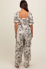 woman wearing a maternity floral jumpsuit with short puff sleeves and a smocked back, showing a relaxed fit