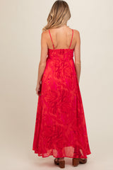 woman wearing a vibrant pink maternity maxi dress with a smocked back and tropical leaf print