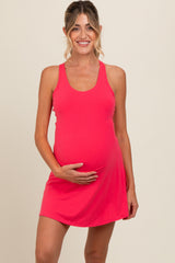 woman wearing a bright pink maternity dress and holding her baby bump