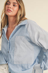 woman wearing a light blue striped button-up shirt with a front pocket