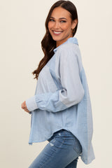 woman wearing a light blue striped maternity button-up shirt with a relaxed fit and long sleeves, smiling at the camera