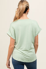 woman wearing a light green short sleeve maternity top, showing a smooth back with a relaxed fit