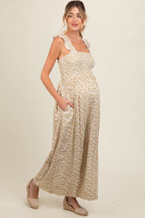 woman wearing a floral print maternity maxi dress with ruffle straps and pockets, showcasing her baby bump