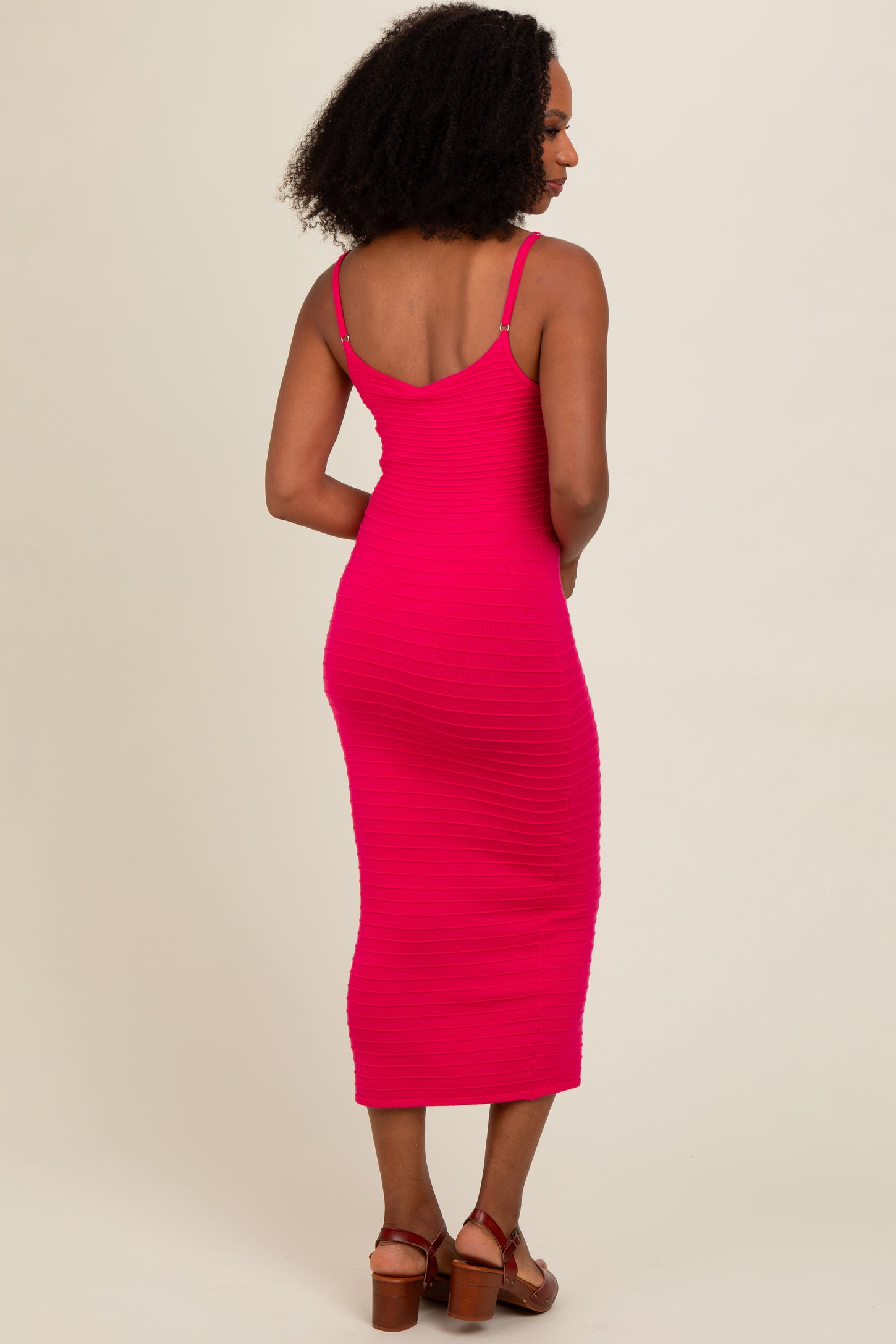 woman wearing a fuchsia ribbed midi dress with spaghetti straps and showing her back