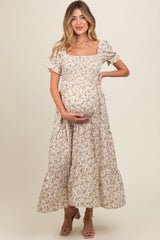 woman wearing a floral maternity dress with puff sleeves and tiered skirt, showing her baby bump