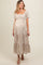 woman wearing a floral print maternity maxi dress with puff sleeves and a smocked bodice, showcasing her baby bump