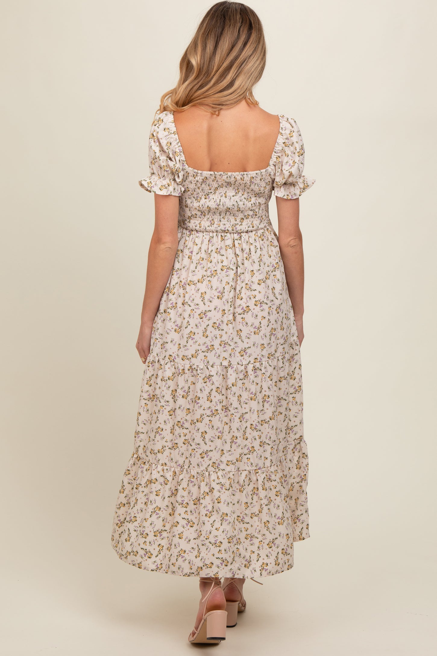 woman wearing a floral maternity maxi dress with a smocked bodice and puff sleeves from the back