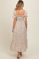 woman wearing a floral maternity maxi dress with a smocked bodice and puff sleeves from the back