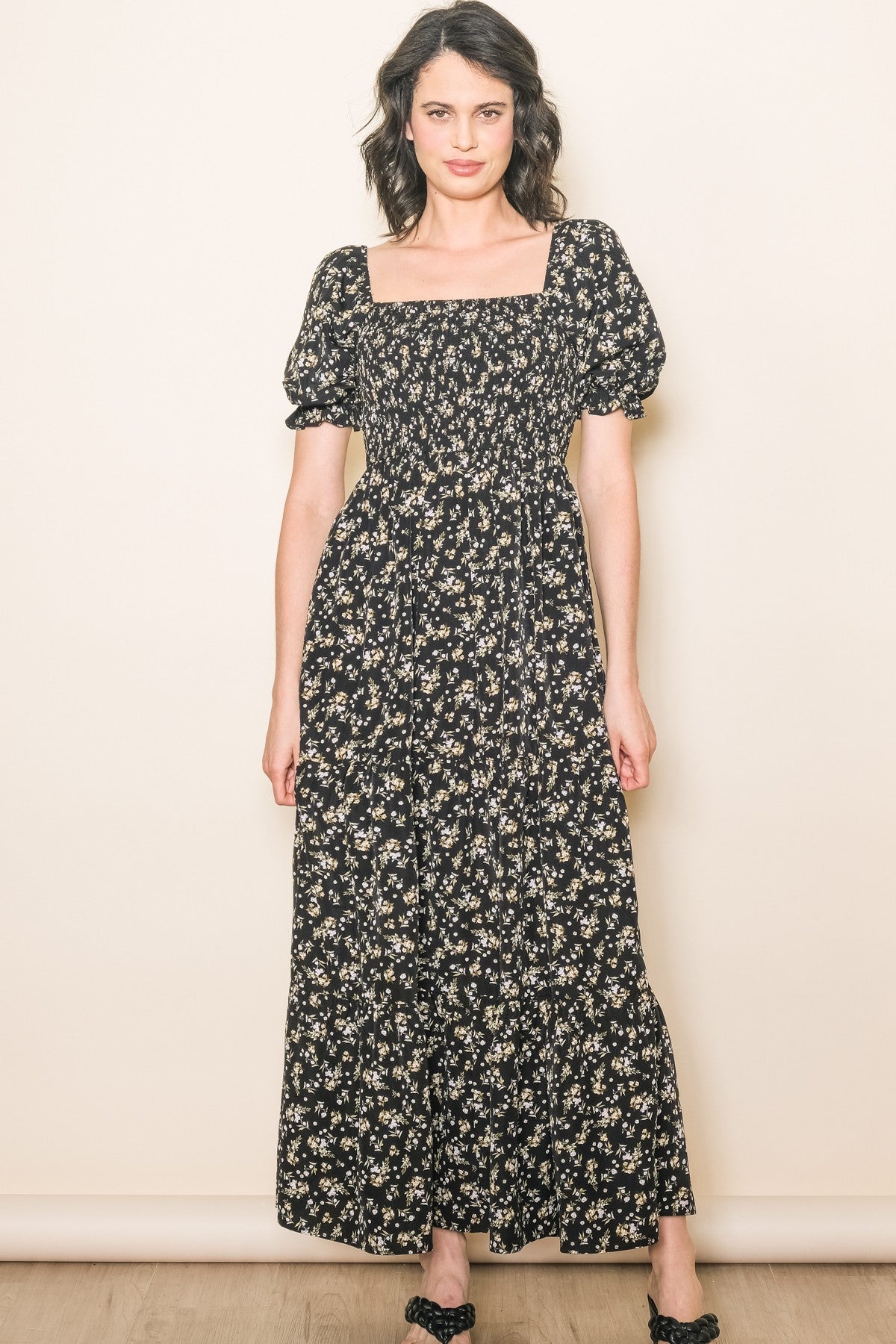 woman wearing a black floral maxi dress with short puff sleeves and a square neckline
