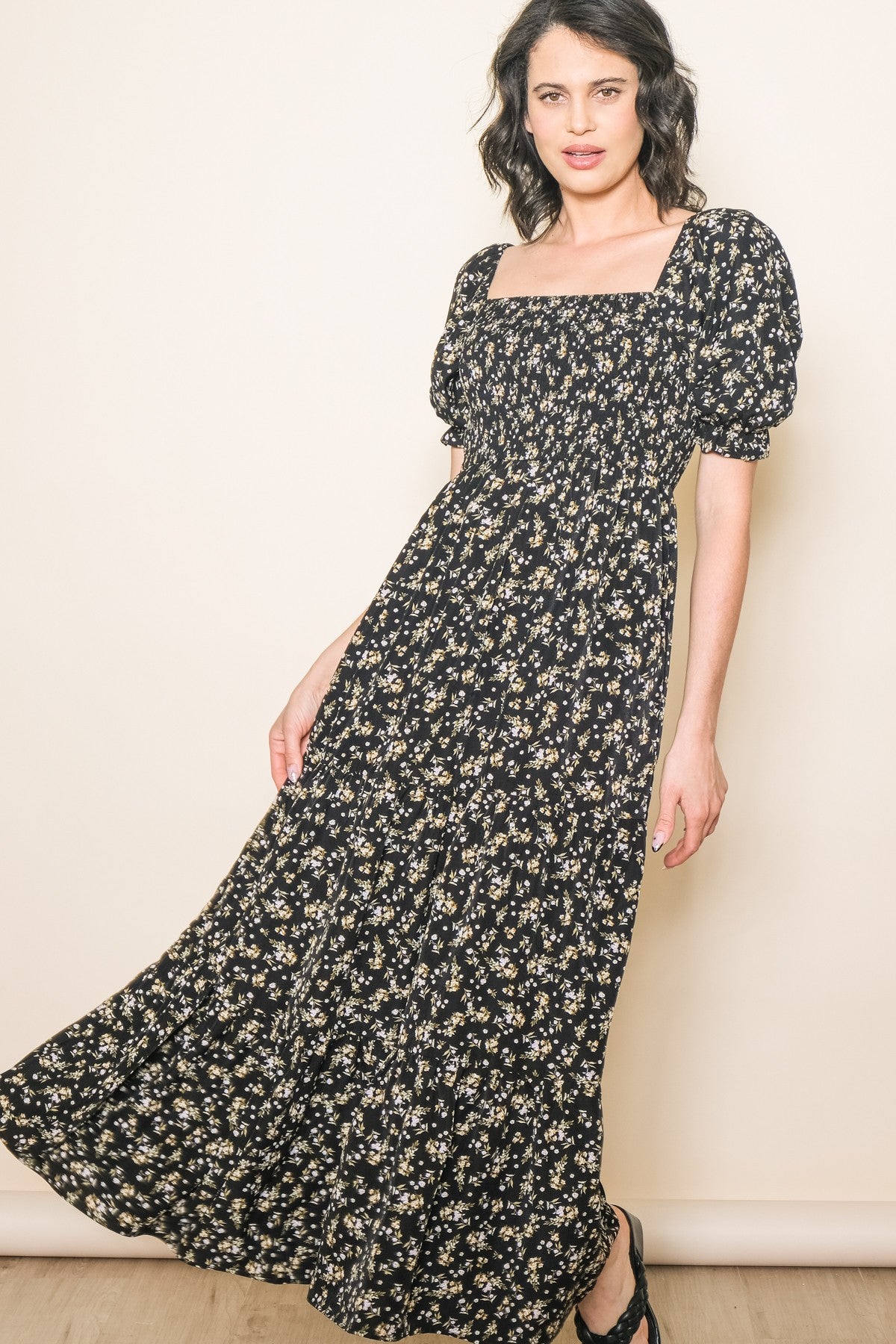 woman wearing a black floral maxi dress with puff sleeves and a square neckline