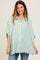 woman wearing a light green striped maternity shirt with a relaxed fit and short sleeves