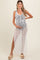 woman wearing a black and white striped maternity cover-up dress while holding her baby bump